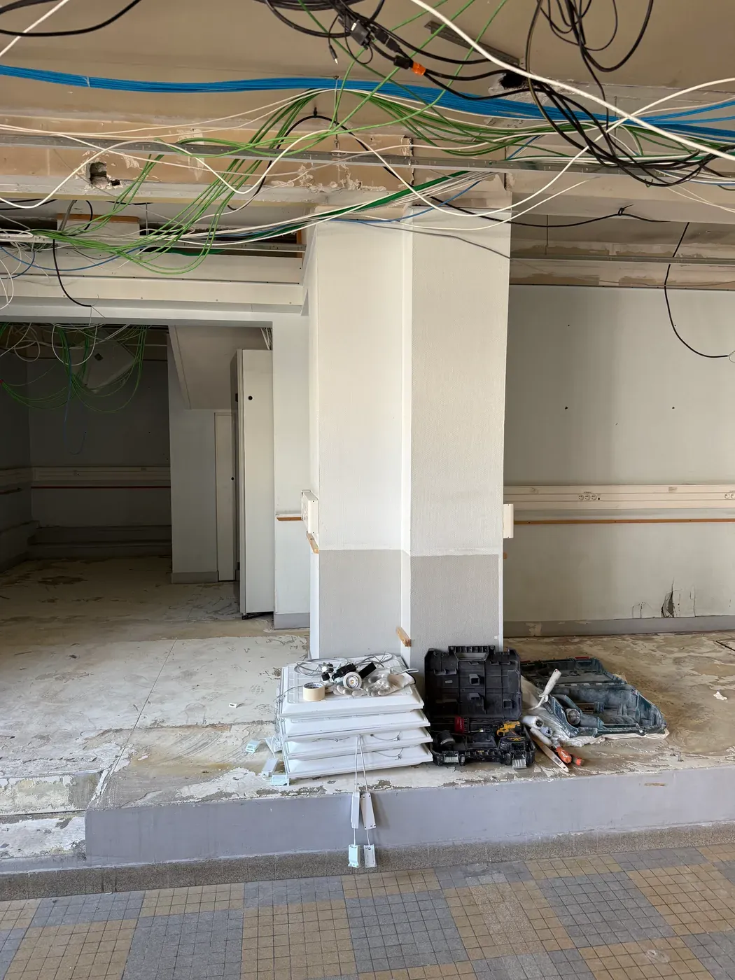 Plateau mis à nu pendant les travaux : réseaux apparents en plafond et sol décapé