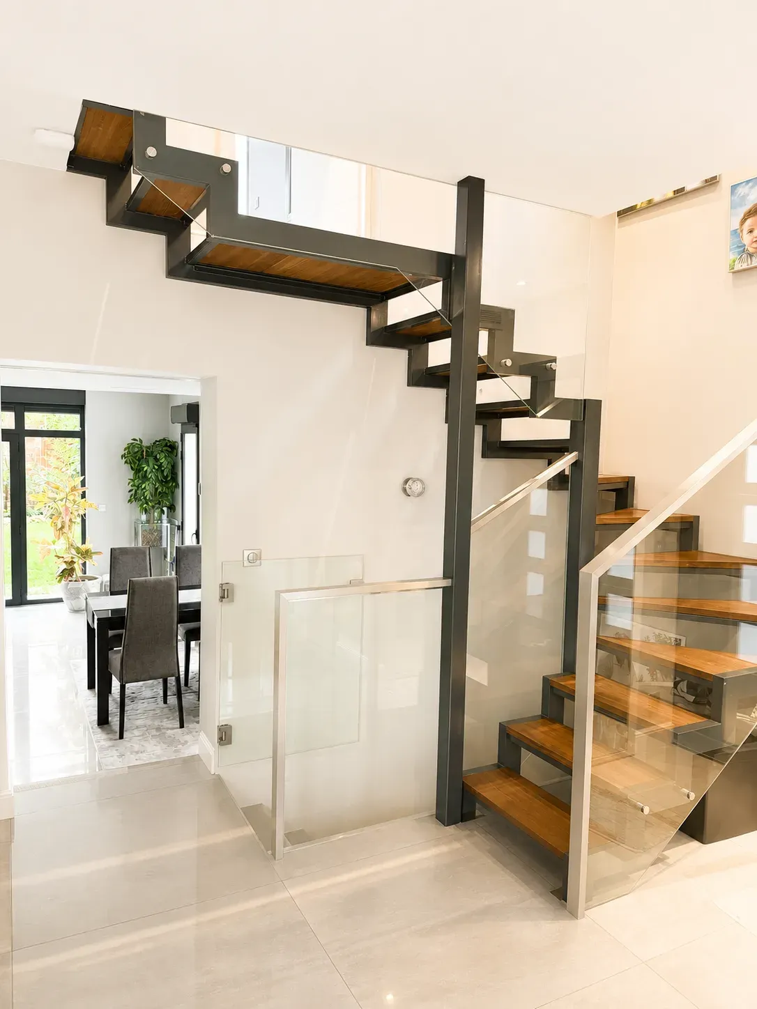 Escalier design en acier et bois ouvrant sur un séjour rénové