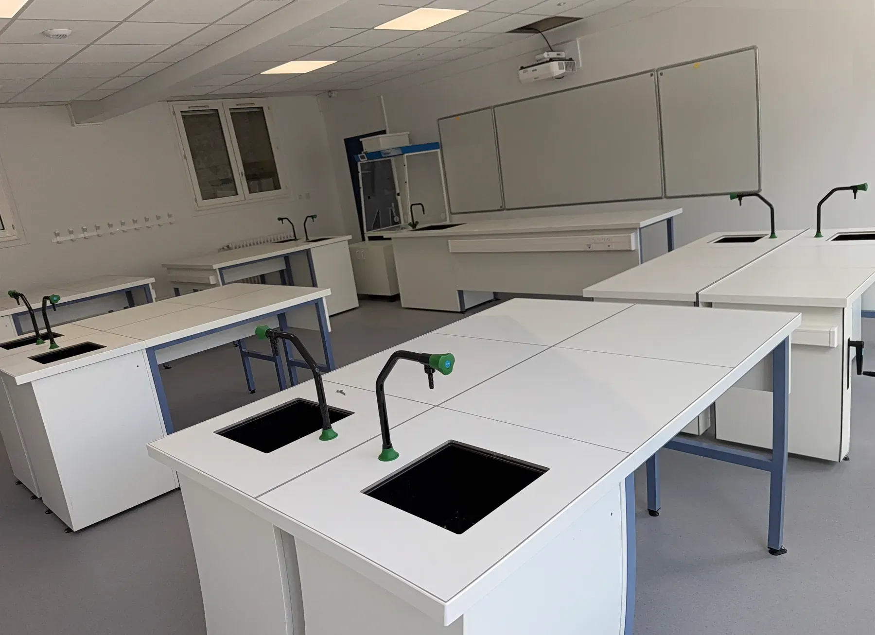 Laboratoire d'enseignement rénové à Chaville : paillasses blanches, robinetterie de laboratoire et éclairage LED