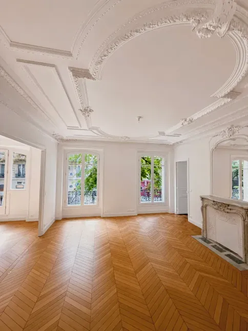 Salon haussmannien restauré : rosace et moulures en plâtre, cheminée en marbre