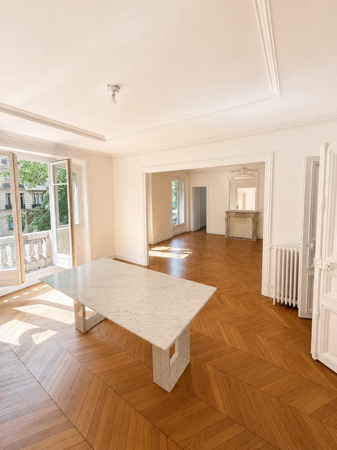 Grand séjour haussmannien rénové, parquet à bâtons rompus et cheminée en marbre